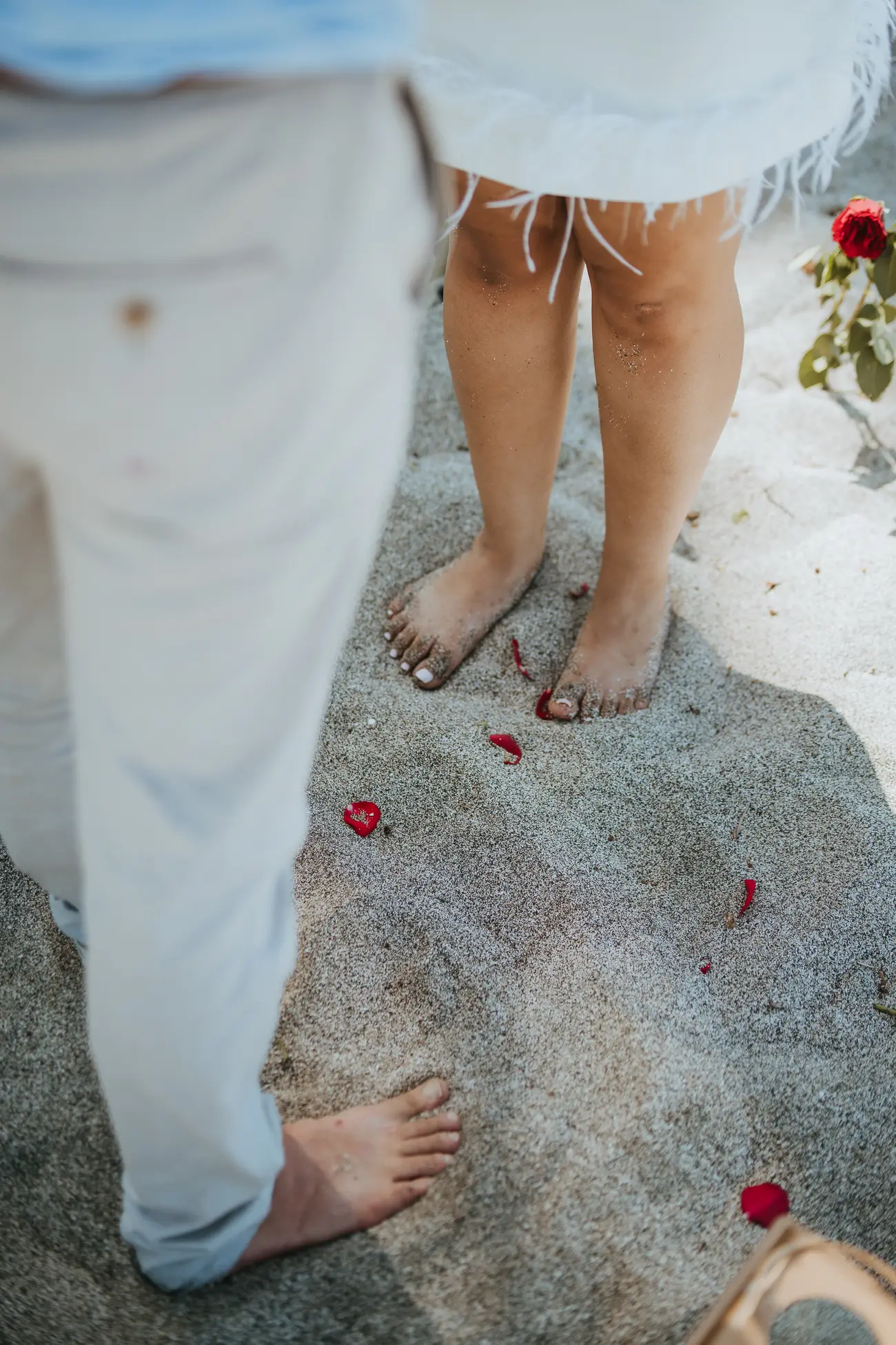 Pétales sur le sable, détail des pieds des mariés